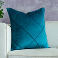 Color-blocked velvet throw pillow covers in blue, yellow, and green styled on a pink sofa