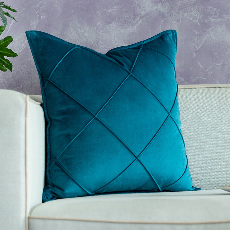 Color-blocked velvet throw pillow covers in blue, yellow, and green styled on a pink sofa